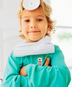 Portrait of a  boy pretending to be a doctor, standing with his arms folded