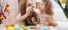 Mother and her baby have fun while painting easter eggs