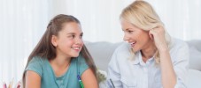 Cheerful mother and daughter writing together