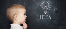 baby child at blackboard with chalk drawn bulb symbol ideas